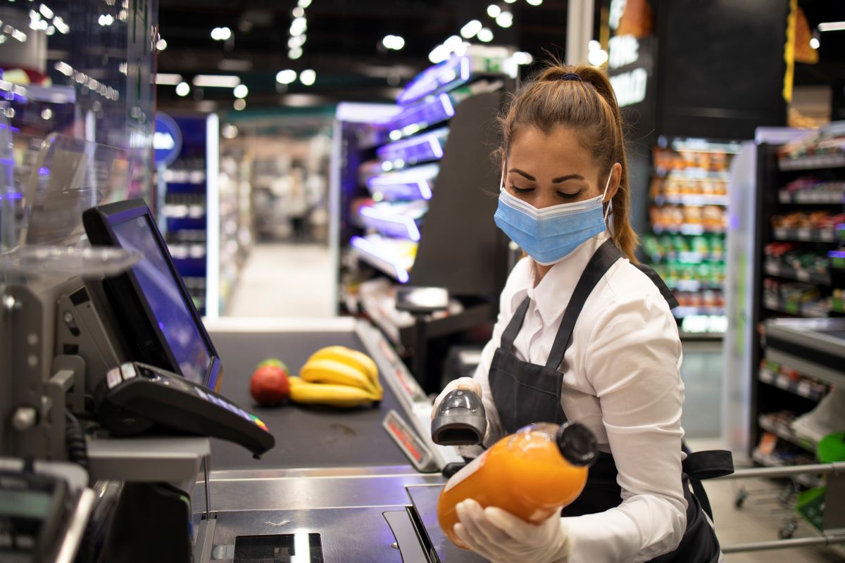 Grocery store checkout cashier with mask